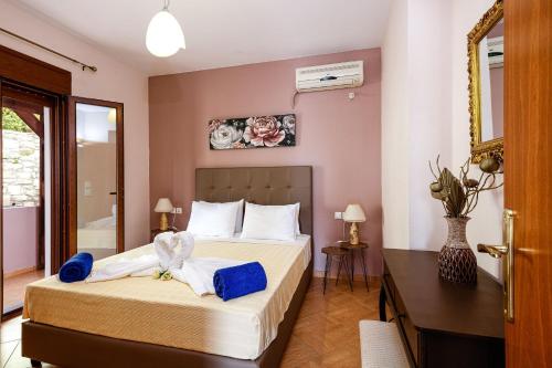 - une chambre avec un lit et des serviettes bleues dans l'établissement Villas Roumeli, à Roumelí