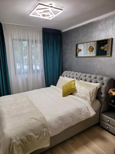 - une chambre avec un grand lit et des rideaux bleus dans l'établissement Central Apartament 2, à Iaşi