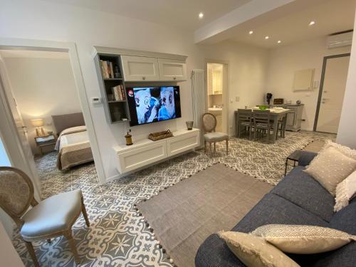 a living room with a couch and a flat screen tv at Suites 5 Stelle nel Borgo di Varazze in Varazze