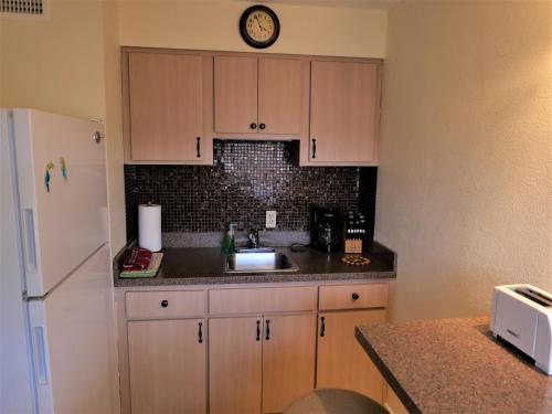 a kitchen with a sink and a refrigerator at Cozy Beach Getaway in Cape Canaveral