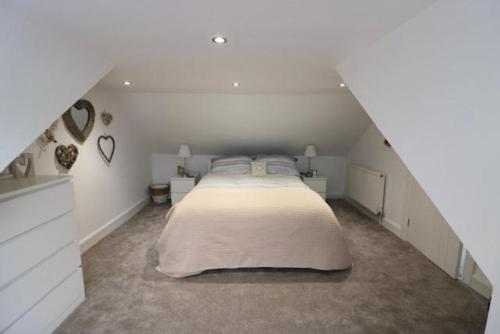 ein Schlafzimmer mit einem großen Bett im Dachgeschoss in der Unterkunft Beachcomber Cottage in Troon