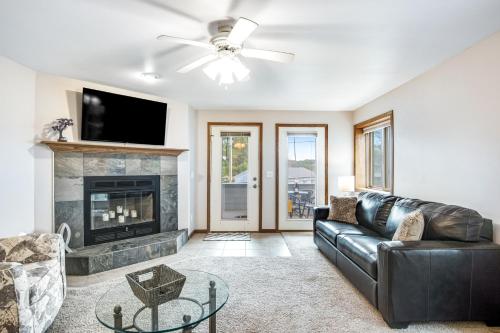 a living room with a leather couch and a fireplace at Lighthouse Cove Condo Resort in Wisconsin Dells