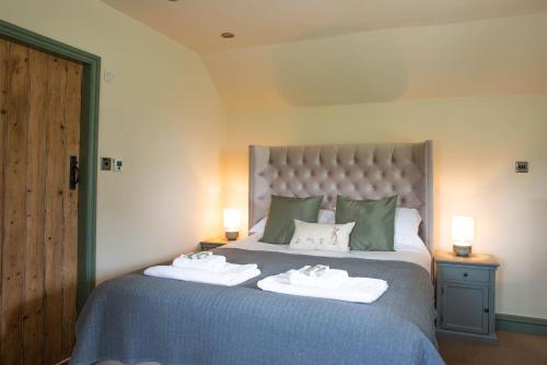 Un pat sau paturi într-o cameră la Brosterfield Cottage