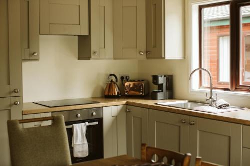 a kitchen with white cabinets and a sink at Galgorm in Ballymena