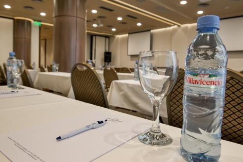 a bottle of water sitting on a table with a glass at Howard Johnson Plaza by Wyndham Buenos Aires Florida Street in Buenos Aires