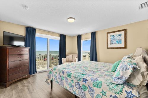 a bedroom with a bed and a tv and a window at Pier Watch in Flagler Beach