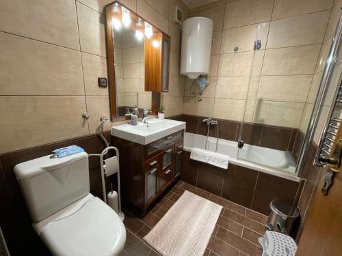 a bathroom with a toilet and a sink and a tub at Riverside Luxury Apartment in Osijek