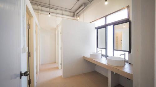 een badkamer met 2 wastafels en een raam bij I-Sleep Silom Hostel in Bangkok