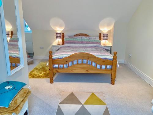 a bedroom with a wooden bed and a mirror at Loft Room @ Sean and Janes in Ballycastle