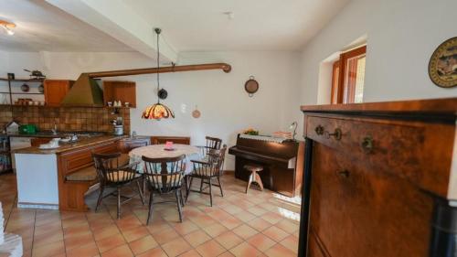 eine Küche und ein Esszimmer mit einem Tisch und einem Klavier in der Unterkunft Villa Gundi in Formia