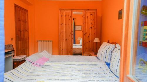 ein Schlafzimmer mit einem Bett in einem orangefarbenen Zimmer in der Unterkunft Villa Gundi in Formia