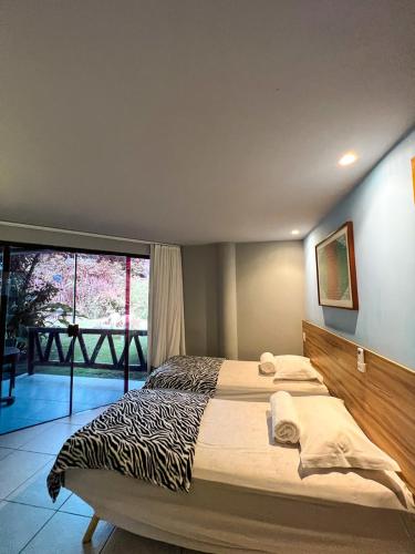 Una cama o camas en una habitación de Pousada Praia dos Carneiros