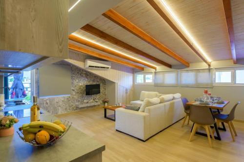 een woonkamer met een witte bank en een tafel bij Contemporary Attic in Preveza