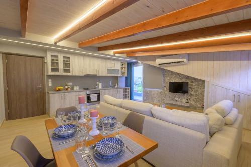 een woonkamer met een bank en een tafel met stoelen bij Contemporary Attic in Preveza