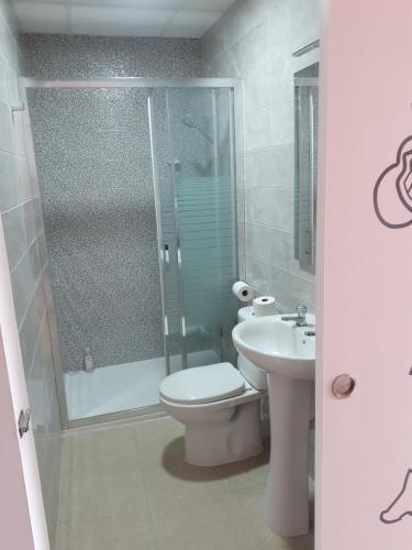 een badkamer met een douche, een toilet en een wastafel bij ALBERGUE LEMAVO in Monforte de Lemos