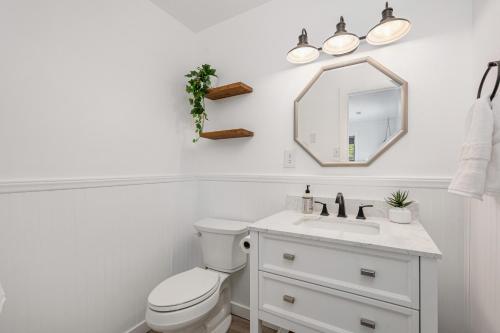 a bathroom with a white toilet and a mirror at Offshore Winds - KDH112 in Kill Devil Hills