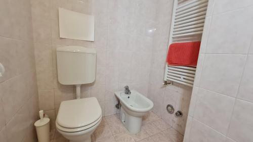 Un baño blanco con inodoro y lavabo. en Fiorilli House - Fair District - Gratis Private Parking, en Bolonia