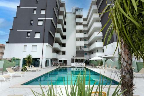 ein Hotel mit einem Pool vor einem Gebäude in der Unterkunft Nero D'Avorio Aparthotel & SPA in Rimini