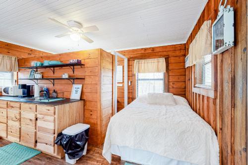a bedroom with a bed and a kitchen in a cabin at Cozy Cabin in Sevierville