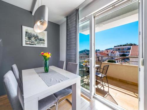 a dining room with a table and chairs and a balcony at Apartment Corto Maltese in Dubrovnik