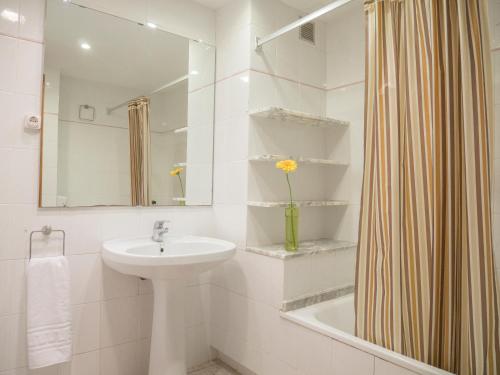 a white bathroom with a sink and a shower at Apartamentos Sol Y Mar in Alcossebre