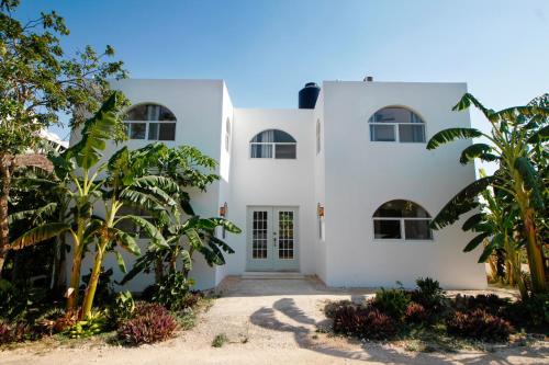 une maison blanche avec des palmiers devant elle dans l'établissement Coco Resort & Villas, 