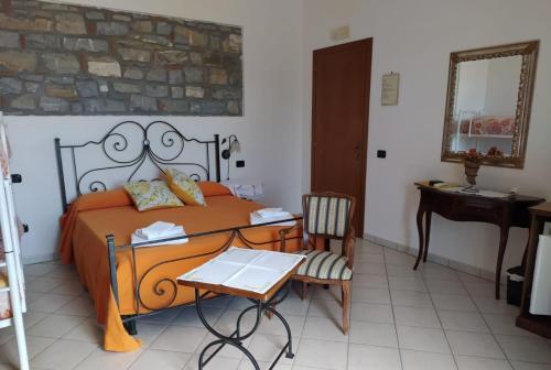 1 dormitorio con cama, escritorio y espejo en Anna dei Sapori, en Castelnuovo Cilento