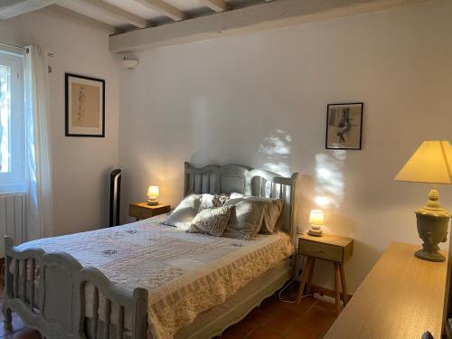 a bedroom with a bed and two lamps and a window at Lou Mas in Gordes