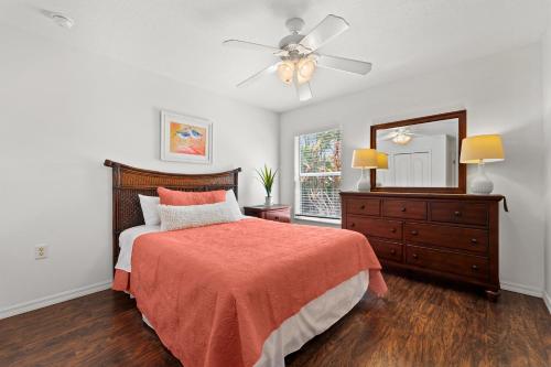 a bedroom with a bed and a dresser and a ceiling fan at Port Charlotte Chateau in North Port