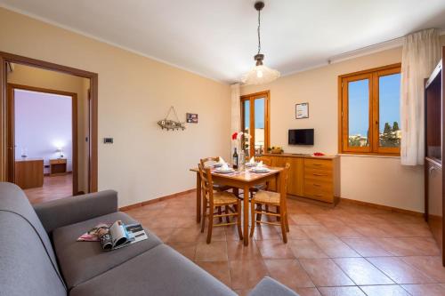 ein Wohnzimmer mit einem Sofa und einem Tisch in der Unterkunft Residence I Tesori di San Vito in San Vito lo Capo