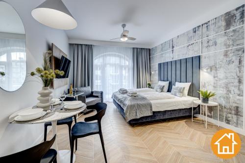 a bedroom with a bed and a table and chairs at Apartamenty Promenada - visitopl in Świnoujście