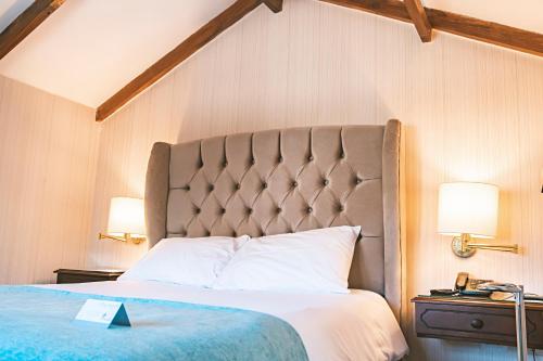 a bedroom with a large bed with a large headboard at Hotel Hanan Deluxe in Arequipa