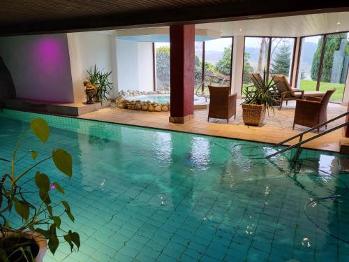 una gran piscina con sillas en una casa en Berghotel Habbel und die Welt kann warten, en Cobbenrode
