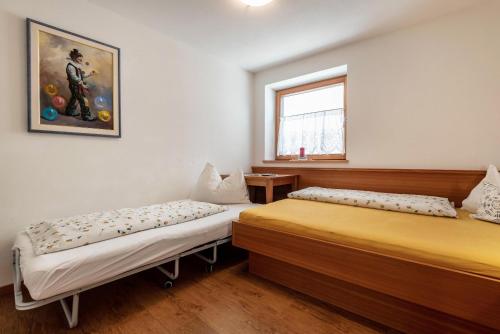 a bedroom with two beds and a window at Huberhof App Golden Delicious in Feldthurns