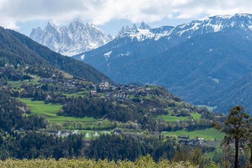 a village in a valley with mountains in the background at Huberhof App Golden Delicious in Feldthurns