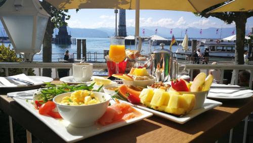 a table with plates of food on a table with a view of the water at Alte Konditorei in Lindau