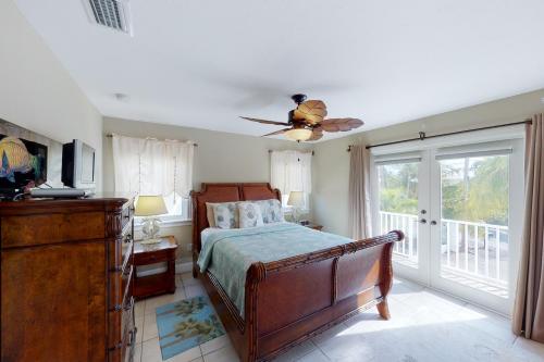 1 dormitorio con 1 cama y ventilador de techo en The Mermaid Manor en Cudjoe Key