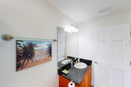 a bathroom with a sink and a painting on the wall at The Mermaid Manor in Cudjoe Key