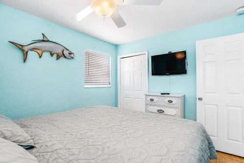 a bedroom with a bed and a fish on the wall at Yellowtail House in Marathon