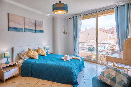 Un dormitorio con una cama azul con un animal de peluche. en Grand Studio Cannes Centre, en Cannes