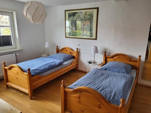 two twin beds in a room with two lamps at Gästehaus Domänenblick in Morschen