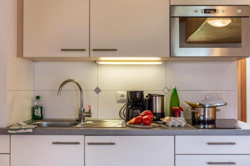 a kitchen with a sink and a microwave at Huberhof Appzimmer in Feldthurns