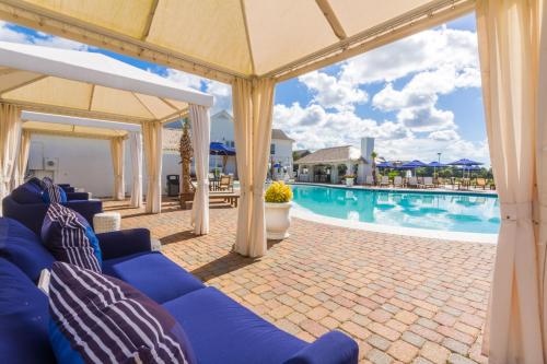 a patio with a blue couch and a swimming pool at One Club Gulf Shores in Gulf Shores