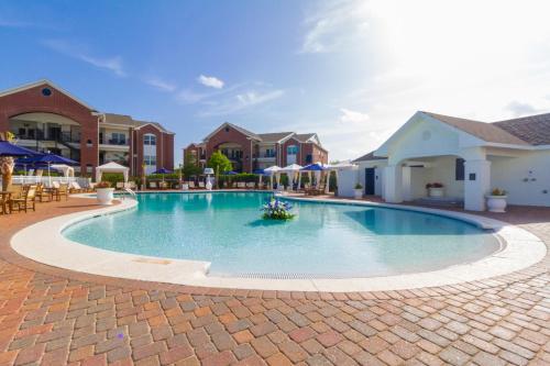 a swimming pool at a resort with chairs and umbrellas at One Club Gulf Shores in Gulf Shores