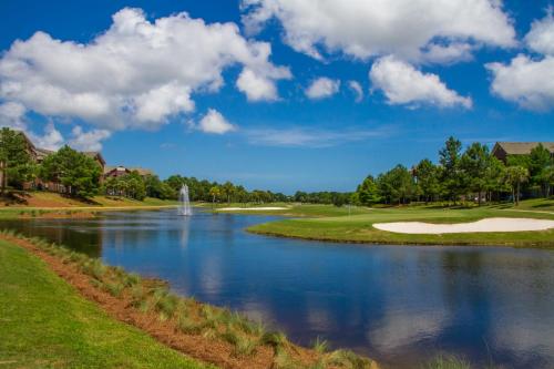 a view of a golf course with a pond at One Club Gulf Shores in Gulf Shores