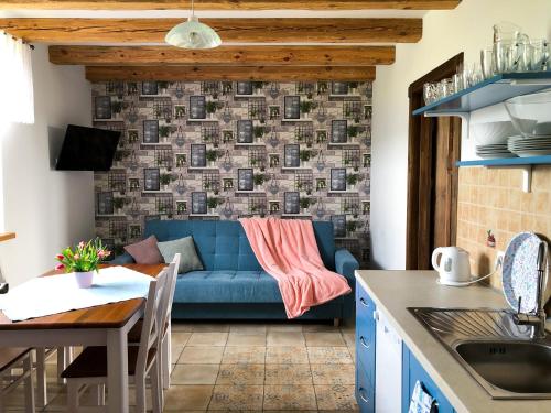 uma cozinha e sala de estar com um sofá azul em WIEJSKI APARTAMENT W DOMU NAD JEZIOREM em Mikołajki
