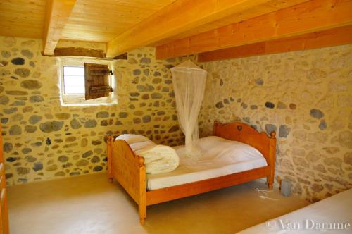 - une petite chambre avec un lit en bois dans une maison dans l'établissement Gîtes du Domaine des Dames, à Vallon-Pont-dʼArc