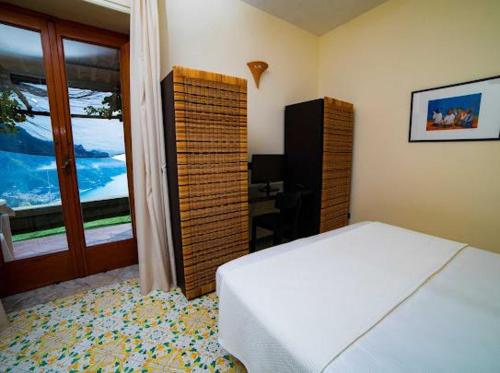 ein Schlafzimmer mit einem weißen Bett und einem Fenster in der Unterkunft Da Salvatore B&B in Ravello