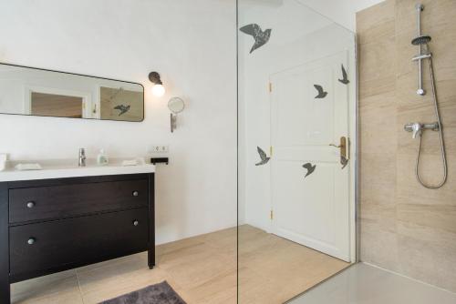 La salle de bains est pourvue d'un lavabo et d'une douche avec un miroir. dans l'établissement Casa La Limonera. Townhouse with pool for up to 6 persons in Santanyi, à Santanyí