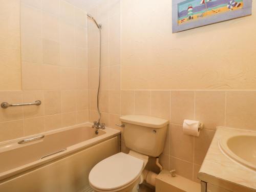 a bathroom with a toilet and a tub and a sink at Owls Retreat in Weston-super-Mare